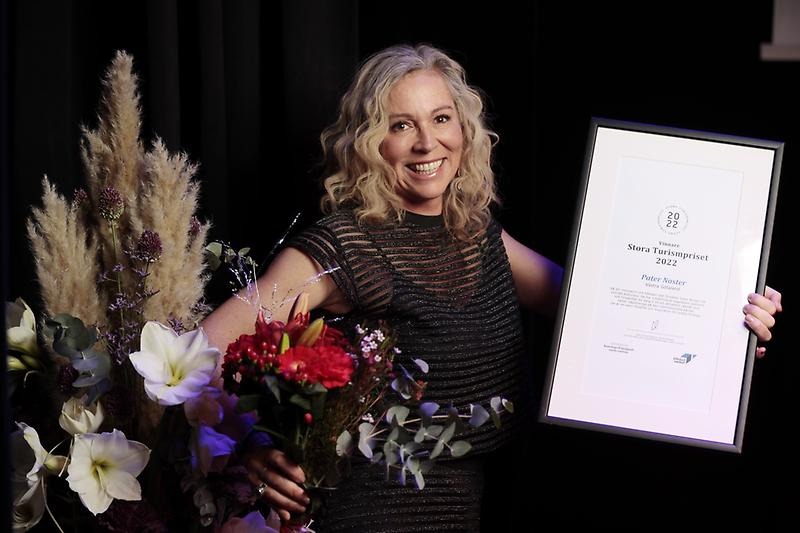 Mirja Lilja Hagsjö, vd på Pater Noster. Hon håller i ett plakat och blommor och ler mot kameran.