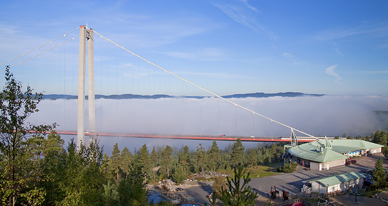 Vy över hotellet och höga-kustenbron i dimma i bakgrunden.