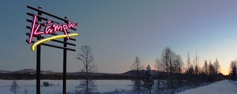 Neonskylt med texten "Kämpa" på en landsväg i skymning.