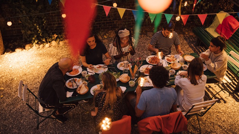 Flera personer runt ett middagsbord utomhus
