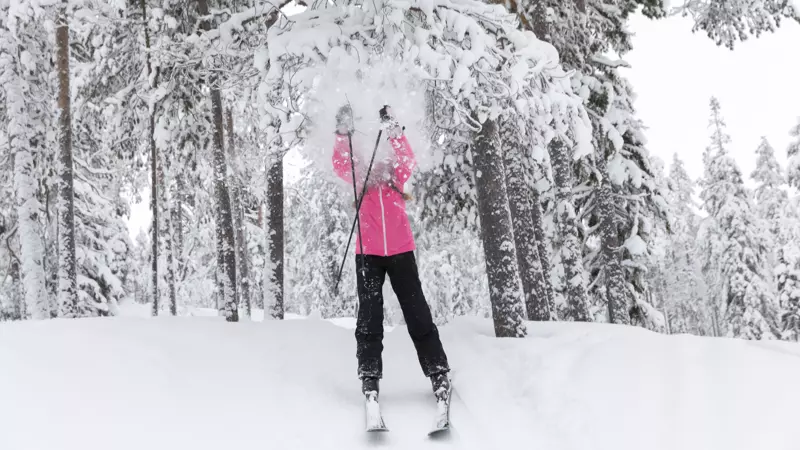 Flicka på skidor i snömoln