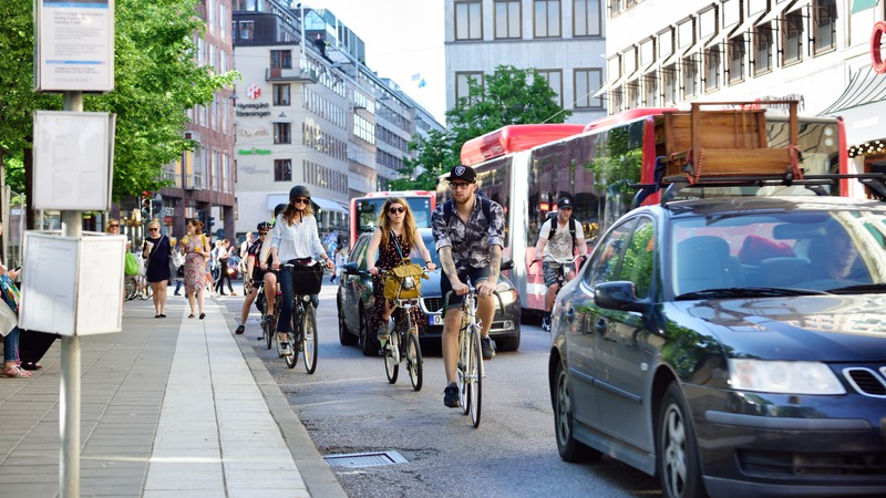 Stockholm, Sweden - June 2, 2016: Early summer day in  environment friendly Stockholm. Bikes and buses in traffic, bus stop sign close by. Kungstradgarden in central Stockholm.