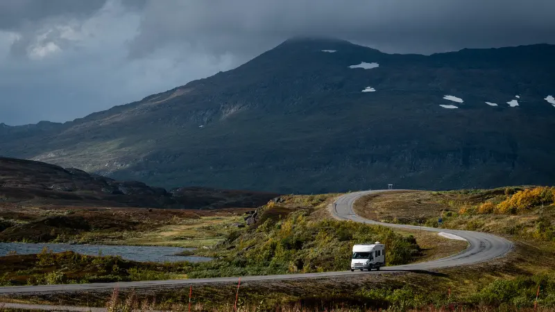 En husbil kör i ett landskap med mycket berg