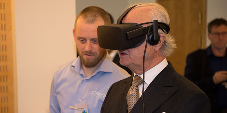 Kung Carl XVI Gustaf tittar i en VR-kamera.