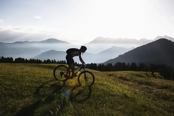 Person som cyklar mountainbike vid ett fjäll.